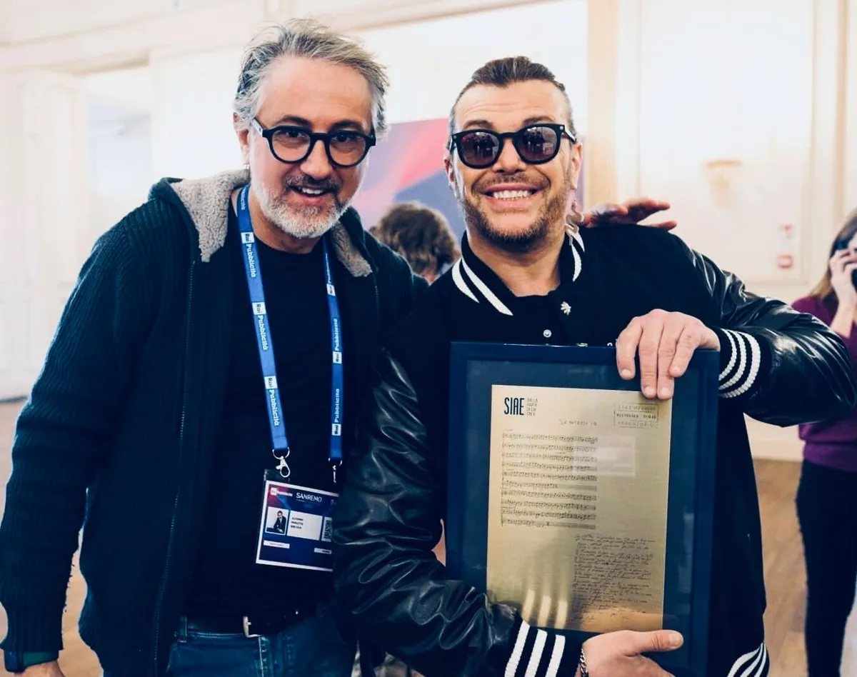 Alfonso Paoletta con un artista che mostra una targa