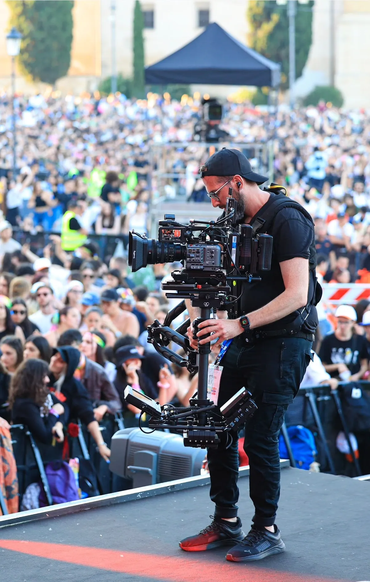 Operatore con steadycam davanti alla folla del Concerto del Primo Maggio